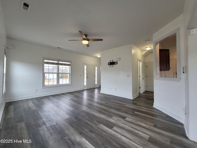 unfurnished living room featuring a ceiling fan, dark wood-type flooring, baseboards, and visible vents