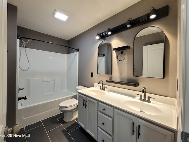 full bath featuring tile patterned floors, toilet, double vanity, and a sink