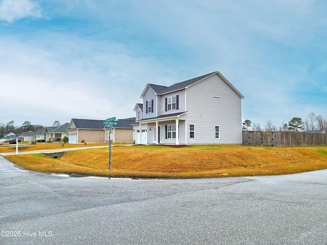 view of front facade with a front lawn and fence