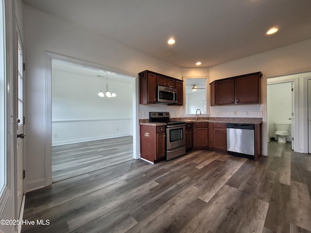 kitchen featuring a sink, stainless steel appliances, dark wood-type flooring, and recessed lighting