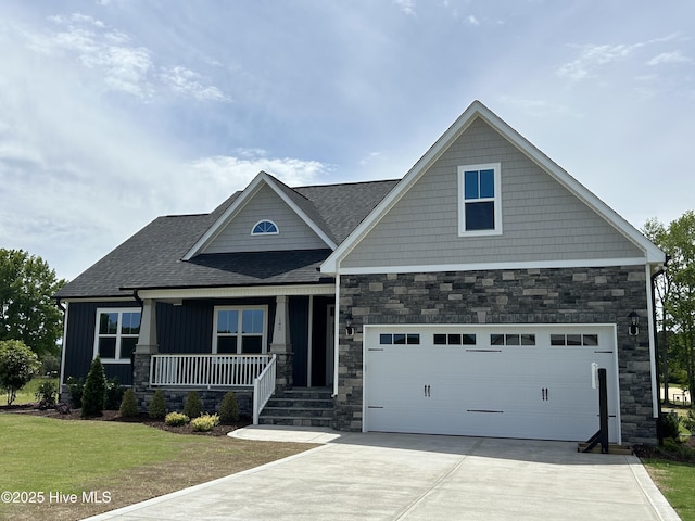craftsman house featuring stone siding, covered porch, driveway, board and batten siding, and roof with shingles