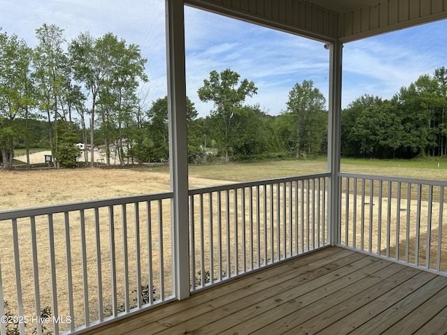 wooden deck featuring view of wooded area and a lawn