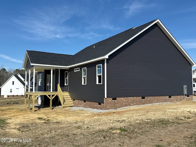 view of home's exterior with crawl space, covered porch, and roof with shingles