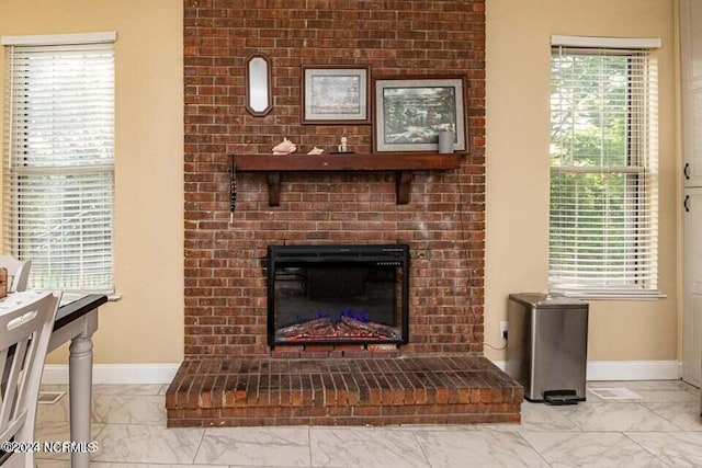 room details featuring a brick fireplace and baseboards