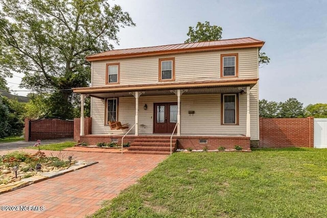 view of front of property with covered porch, a gate, fence, french doors, and a front lawn