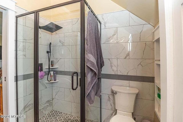 bathroom with a shower stall and toilet