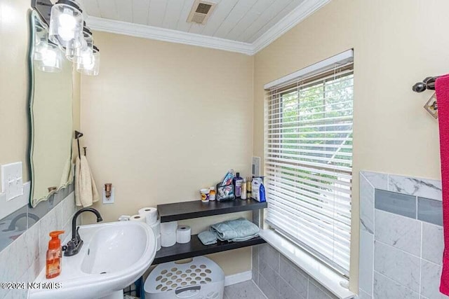 bathroom with a sink, visible vents, and crown molding