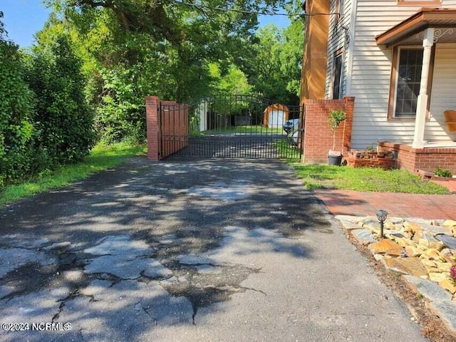 view of road with aphalt driveway, a gated entry, and a gate