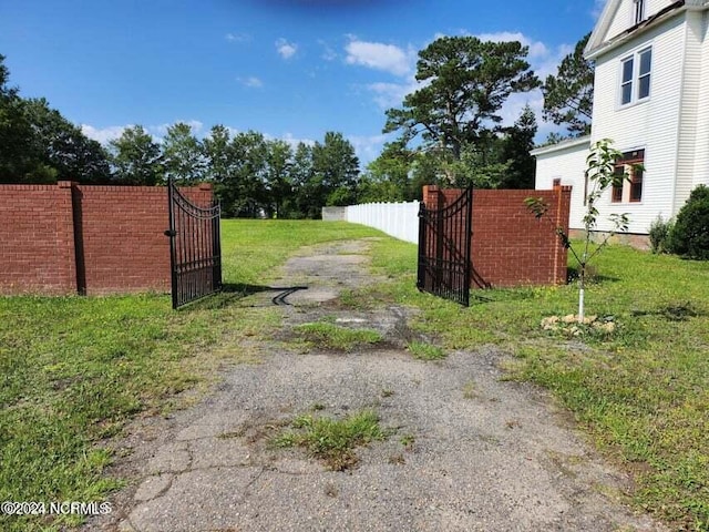 view of gate with fence and a yard