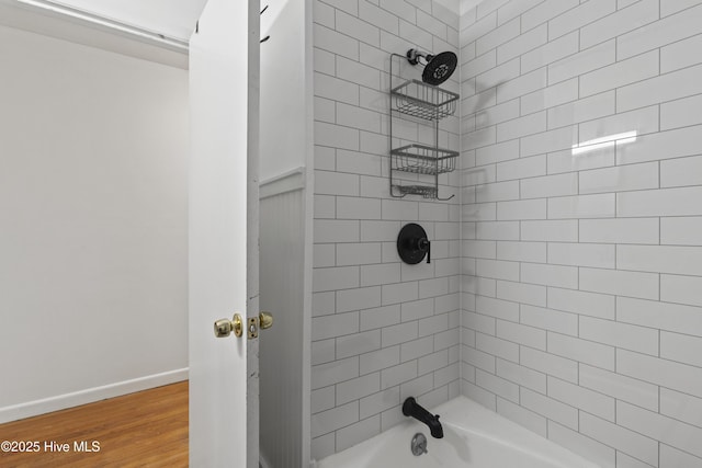 bathroom with  shower combination, wood finished floors, and baseboards