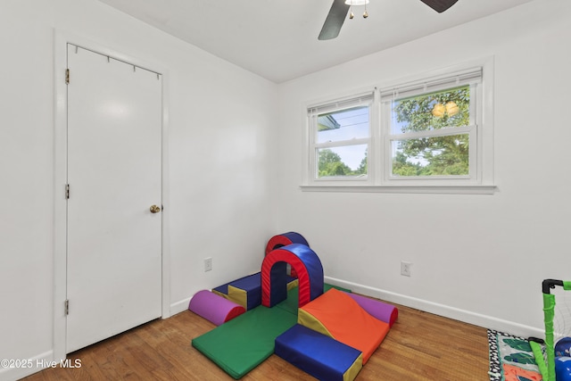 rec room featuring a ceiling fan, baseboards, and wood finished floors