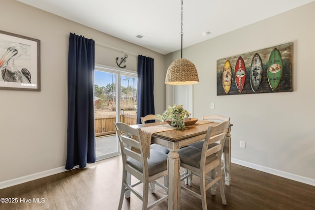 dining room featuring wood finished floors, visible vents, and baseboards