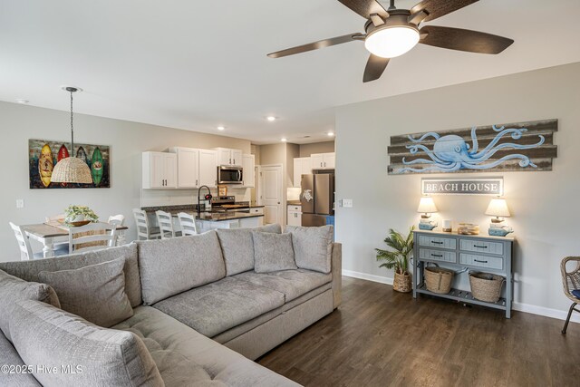 living area featuring a ceiling fan, baseboards, dark wood-style flooring, and recessed lighting