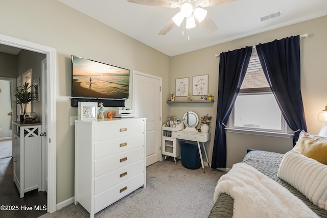 carpeted bedroom featuring baseboards, visible vents, and a ceiling fan