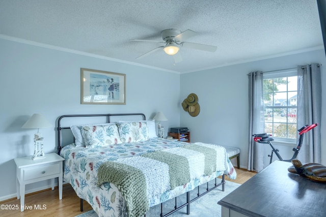 bedroom with a ceiling fan, light wood-type flooring, crown molding, and a textured ceiling