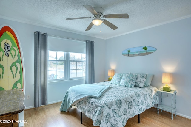 bedroom featuring ornamental molding, a ceiling fan, a textured ceiling, and wood finished floors