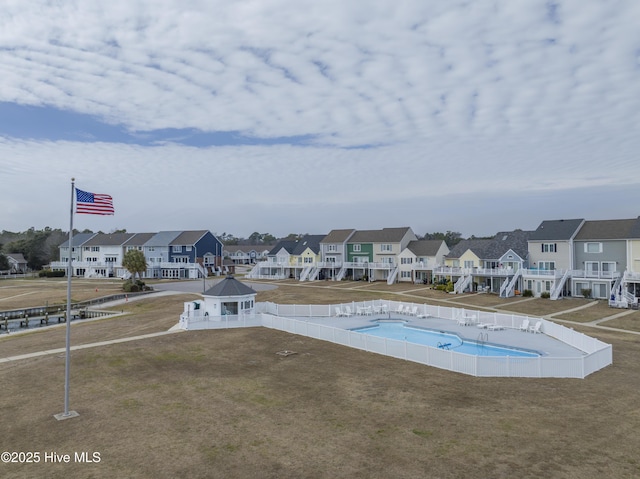 pool featuring a yard, a residential view, and a gazebo