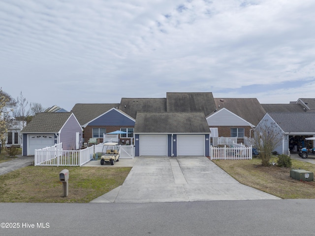 view of front facade featuring a detached garage, fence, an outbuilding, and a residential view