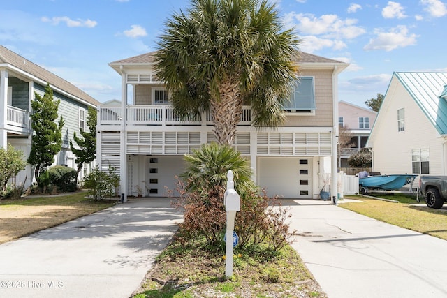 beach home with concrete driveway and a garage