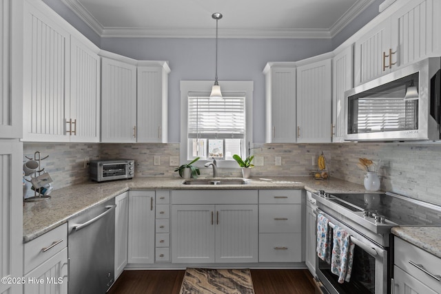 kitchen with ornamental molding, appliances with stainless steel finishes, white cabinets, and a sink