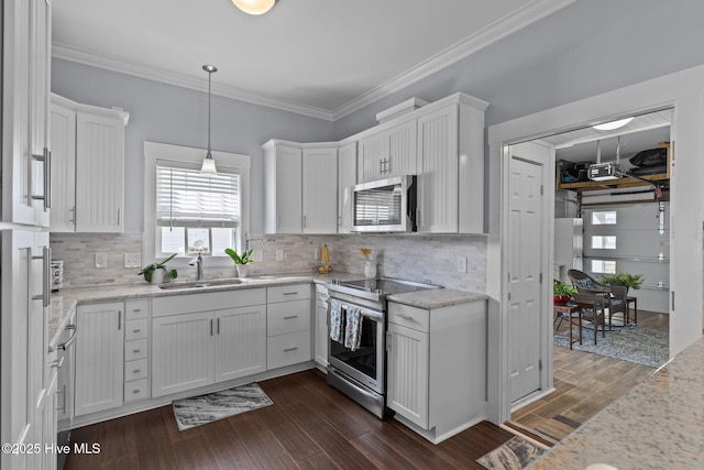 kitchen with a sink, ornamental molding, dark wood-type flooring, white cabinets, and stainless steel appliances