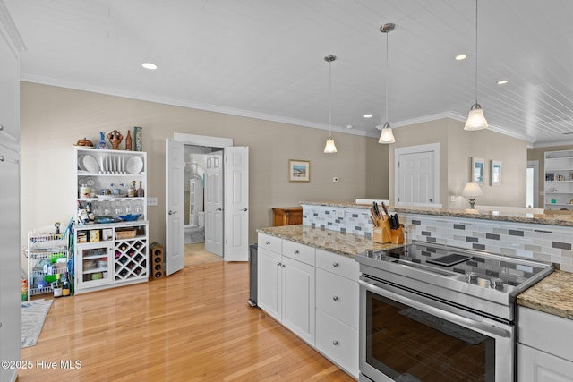 kitchen featuring stainless steel electric range oven, white cabinets, light wood-style floors, and tasteful backsplash