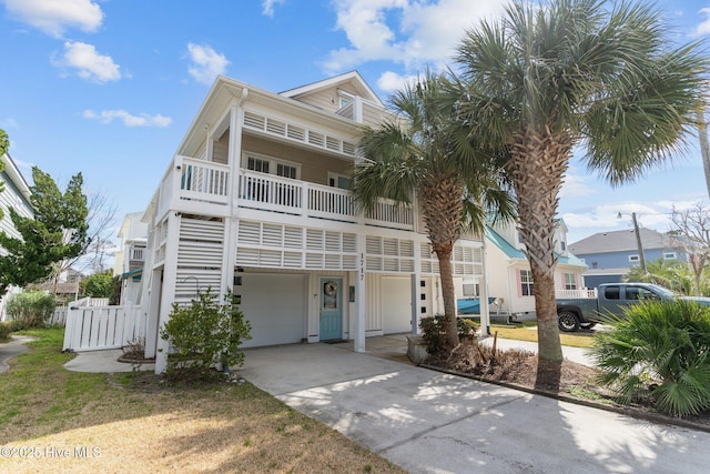 view of front facade featuring a garage, a balcony, and concrete driveway