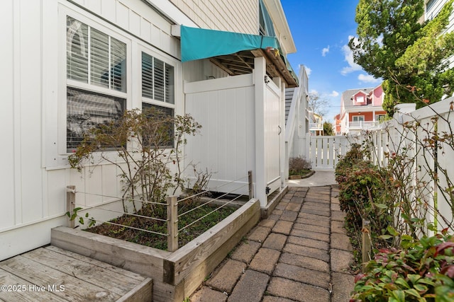 view of property exterior featuring board and batten siding, a vegetable garden, and fence