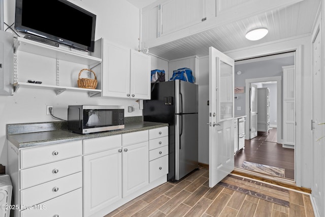 kitchen with wood tiled floor, open shelves, appliances with stainless steel finishes, white cabinetry, and dark countertops