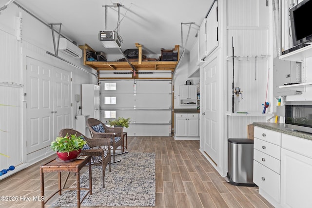 garage with a garage door opener and a wall mounted AC