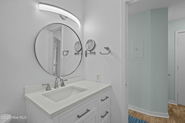 bathroom featuring wood finished floors, vanity, and baseboards