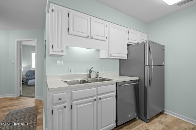 kitchen featuring light countertops, appliances with stainless steel finishes, a sink, and visible vents