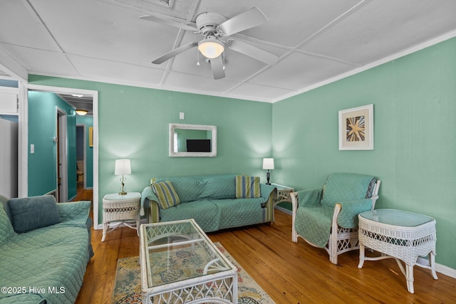 living room with a ceiling fan, wood-type flooring, and ornamental molding