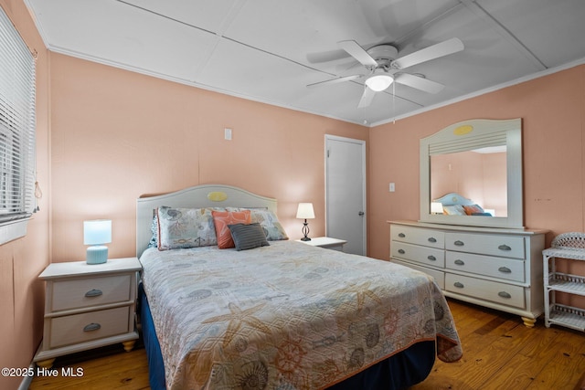 bedroom featuring wood finished floors, a ceiling fan, and crown molding