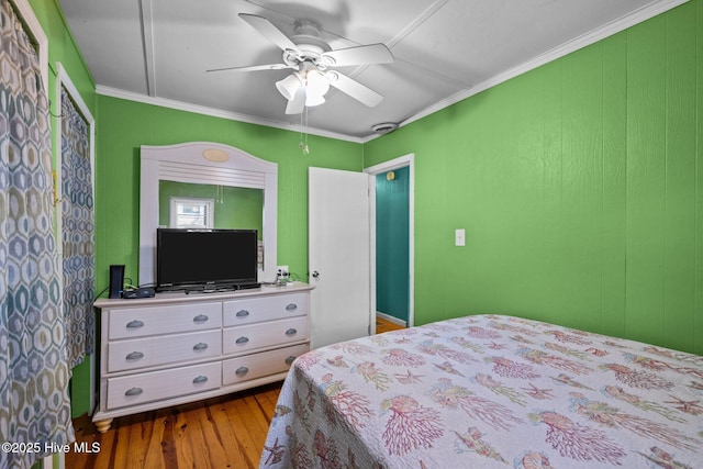 bedroom with a ceiling fan, crown molding, and wood finished floors