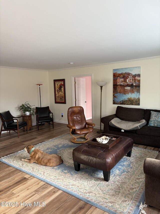 living area with crown molding, baseboards, and wood finished floors