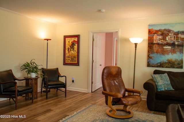 living area with ornamental molding, baseboards, and wood finished floors