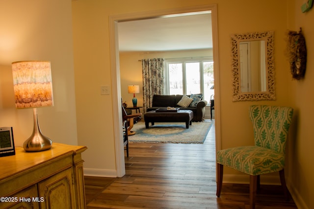 hallway with dark wood-type flooring and baseboards