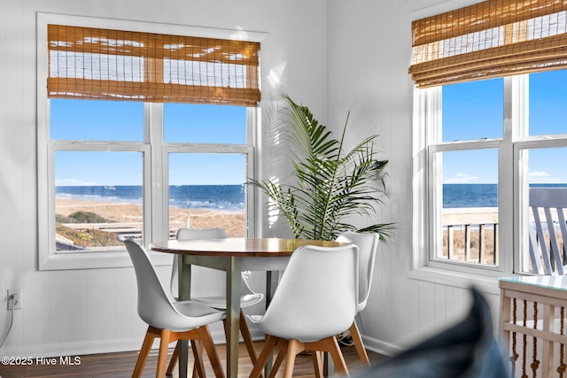 4827 W Beach Dr, Oak Island, NC 28465 - dining space featuring a water view, wood finished floors, and baseboards
