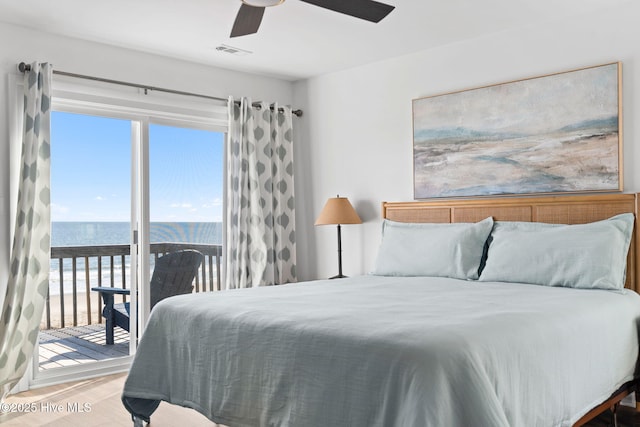 4827 W Beach Dr, Oak Island, NC 28465 - bedroom featuring access to exterior, visible vents, a water view, ceiling fan, and wood finished floors