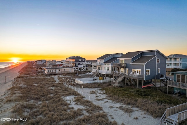 back of house at dusk featuring a residential view and a deck