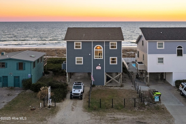 4827 W Beach Dr, Oak Island, NC 28465 - view of front facade featuring a carport, a water view, and dirt driveway