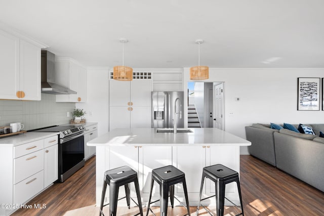 4827 W Beach Dr, Oak Island, NC 28465 - kitchen featuring stainless steel appliances, a kitchen breakfast bar, light countertops, wall chimney exhaust hood, and dark wood finished floors