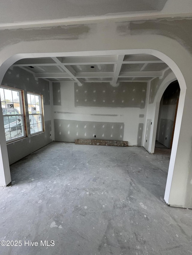 unfurnished living room with arched walkways