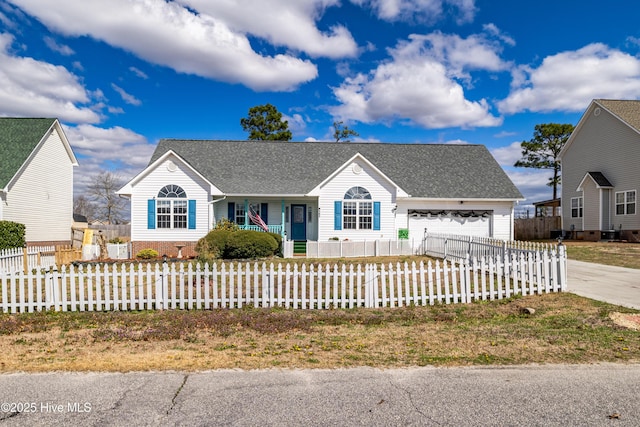 ranch-style home featuring driveway, a fenced front yard, an attached garage, and roof with shingles