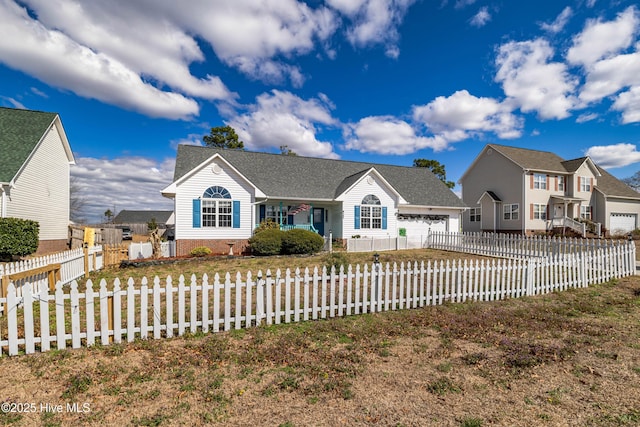 view of front facade featuring a fenced front yard, a residential view, and an attached garage