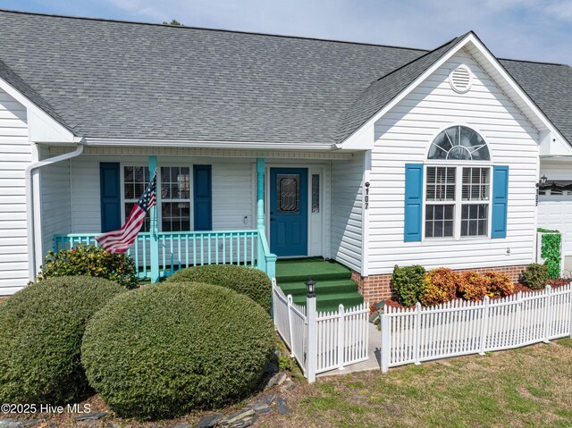 view of front of home with roof with shingles, a fenced front yard, and a residential view