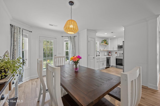 dining space with recessed lighting, visible vents, baseboards, light wood-style floors, and crown molding