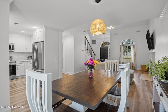 dining space featuring light wood finished floors, stairs, visible vents, and recessed lighting