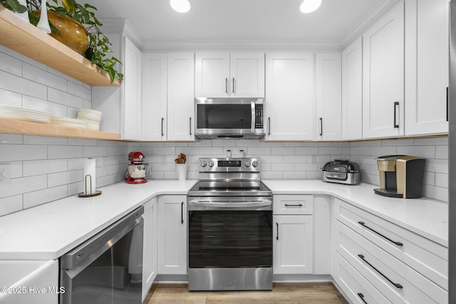 kitchen featuring open shelves, white cabinets, stainless steel appliances, and decorative backsplash